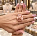 Un anillo moderno, diseño  floral tejido artesanalmente con cristales rosados balines metálicos, engastados con alambre de cobre en tono dorado.