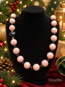 Collar en colores negro y palo rosa con acabados en dorado y acero