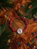 Pulsera artesanal tejida en técnica de macrame en color rojo con el mapa de Costa Rica y un nudo corredizo para ajustarla en la muñeca