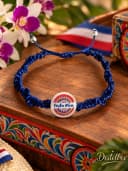 Pulsera tegida con técnica macrame en color azul con pieza central representativa de la decoración de las carreras típicas costarricense